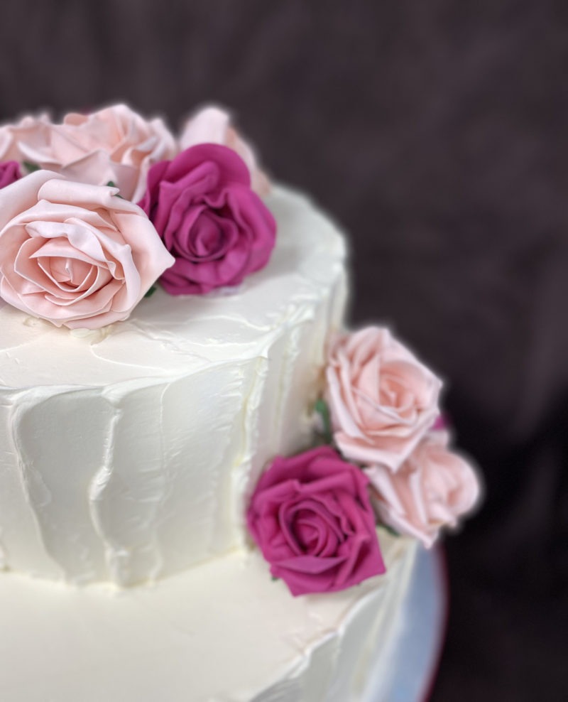 wed 10 scaled <div class="woocommerce-product-details__short-description" style="text-align: center;">Two tier wedding cake with ruffled design and pink flowers</div>