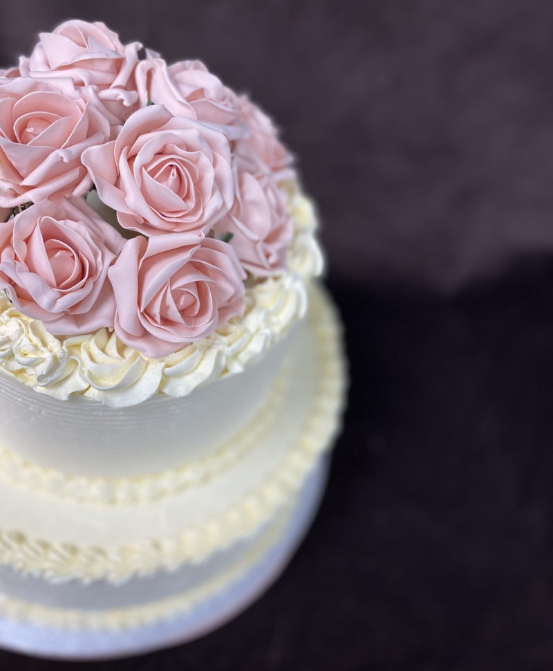 wed 2 scaled <p style="text-align: center;">Two tier wedding cake with a combed design and antique pink flowers</p>