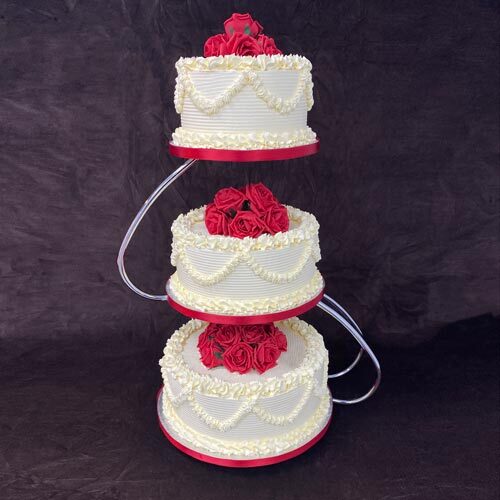 3 Tier wedding cake on a stand with red flowers