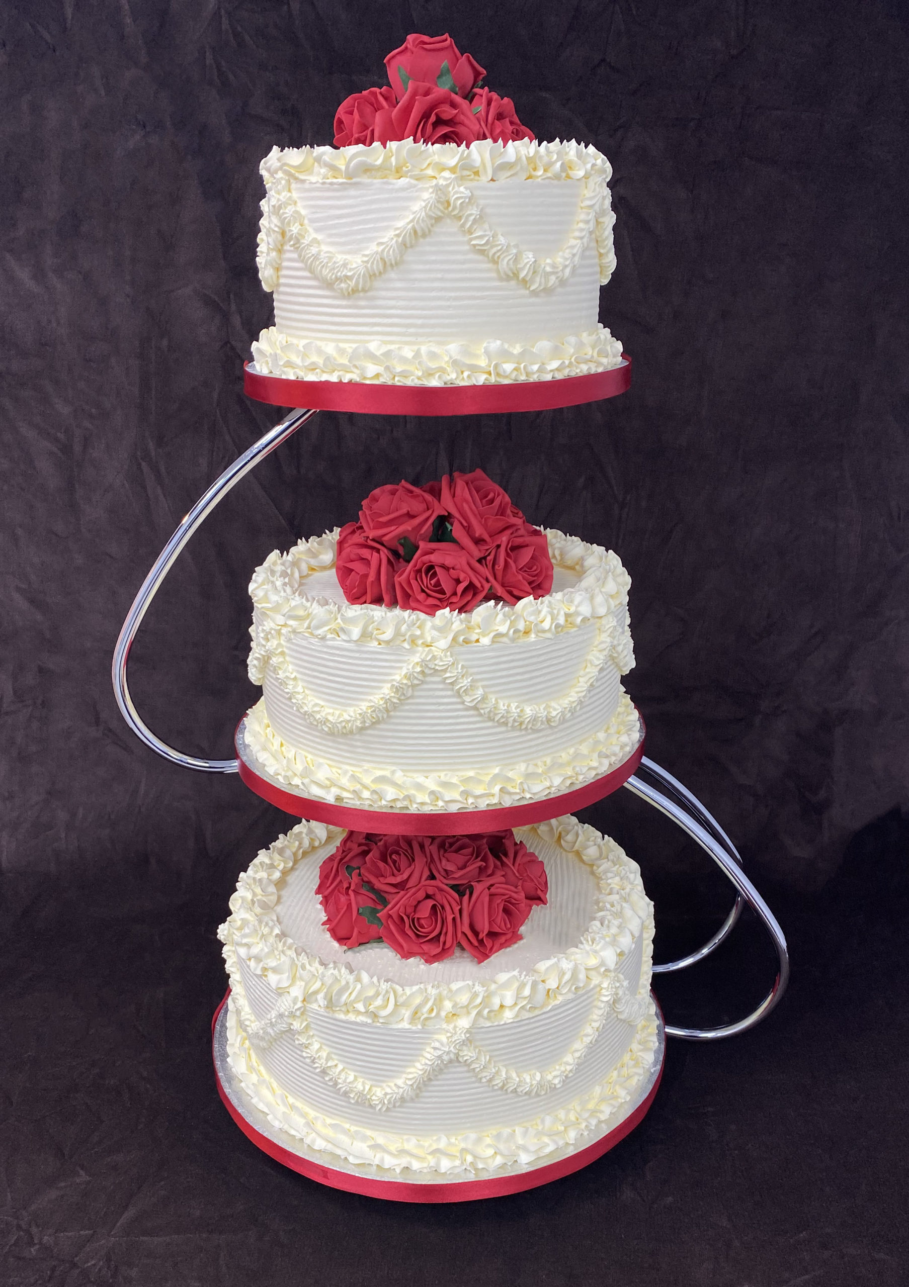 wed 7 scaled <div class="woocommerce-product-details__short-description" style="text-align: center;">3 Tier wedding cake on a stand with red flowers</div>