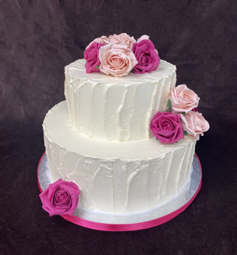 wed 9 1 scaled <div class="woocommerce-product-details__short-description" style="text-align: center;">Two tier wedding cake with ruffled design and pink flowers</div>